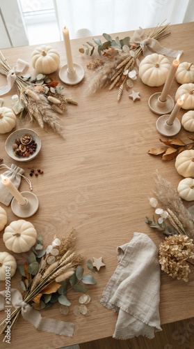 neutral Halloween flat lay background featuring white pumpkins, beige leaves and autumn decorations arranged around a clean central copy space.