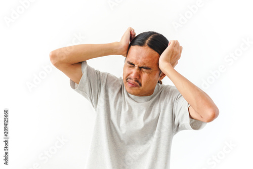 Foto A man with long dark hair clutches his head in evident pain or distress against a clean white background
