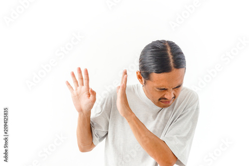 A man with a disgusted expression raises his hands in a stop gesture, warding off something unpleasant.