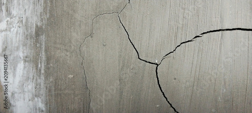 Close-up photo of cracked concrete wall texture