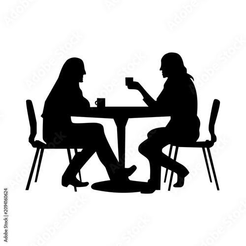 Silhouette of two women sitting at a table talking and drinking coffee in a cafe.