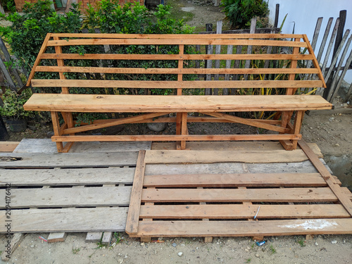 Foto Handmade long wooden bench with high backrest standing on wooden pallets in a ba