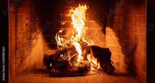 Fireplace burning wood logs. Cozy warm home in winter, Christmas holiday bonfire. Fire flames