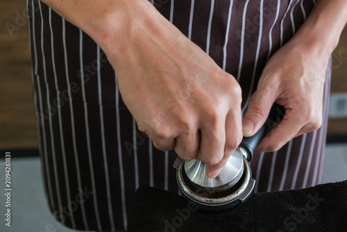 фотографія Hand barista portafilter tamper coffee apron cafe Close up of hands pressing gro