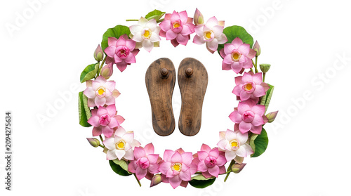 Traditional wooden Guru paduka footwear enclosed in a circular wreath of pink and white lotus blossoms, isolated on a transparent background