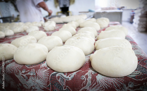 Foto Fresh bread dough portions resting before shaping traditional Uzbek flatbread in an artisan bakery