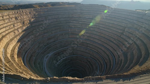 Aerial view of massive open-pit mine with terraced levels, mining industry