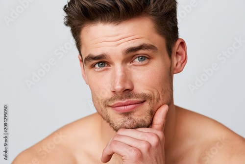 Natural beauty portrait of young man resting chin on hand cal