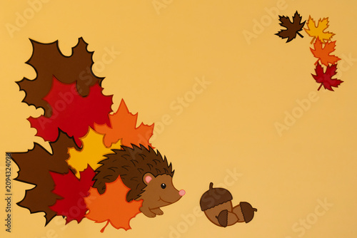Tableau sur toile Hedgehog moves through colorful leaves in autumn setting on a plain background
