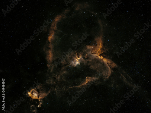 фотографія Vast celestial clouds of glowing gas and dark dust intricately shape the distant Heart Nebula, a star-forming region, seen against a field of countless stars at night