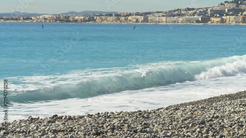 Sea surf splashing over pebbled shoreline