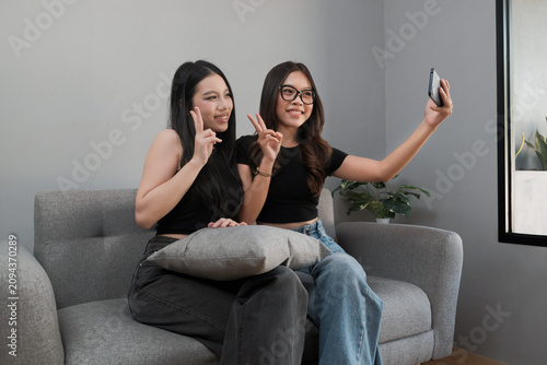Young Asian Female Friends Taking Selfie Together with Smartphone at Home