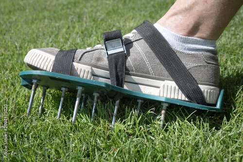 Картината върху платно Lawn aeration using shoe attachments.