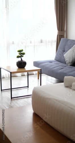 White rolled towels on bed with blurry living room interior background