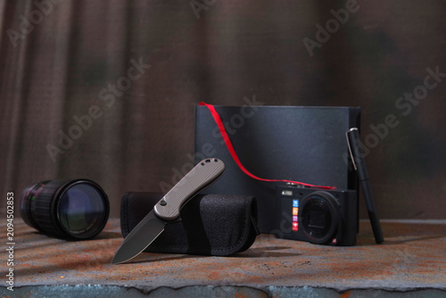 Automatic folding pocket knife under cinematic warm and cool contrast lighting.