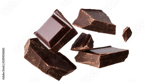Isolated delicious flying dark chocolate pieces, sweet dessert ingredient and gourmet snack.