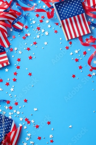 festive patriotic star confetti and striped flags on blue background with curling red ribbons and empty center, cheerful celebratory mood