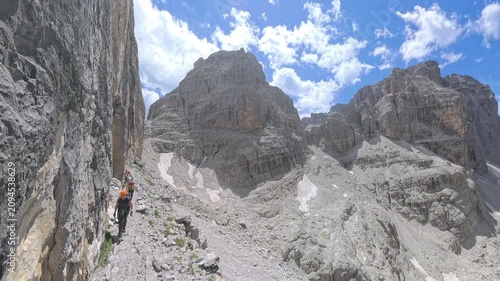 Group of hikers traversing Via Ferrata Bocchette Centrali with panoramic views toward Bocca di Brenta