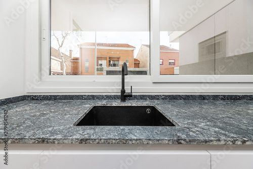 Принти на полотні Modern kitchen sink area featuring a sleek black undermount basin and matching m