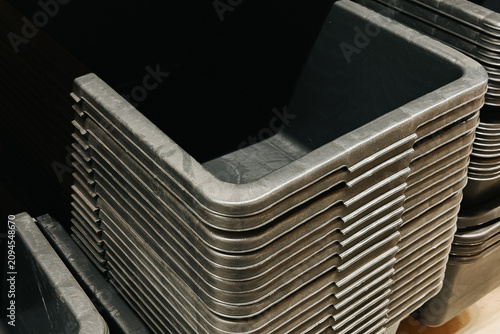 Stack of dark plastic containers in storage