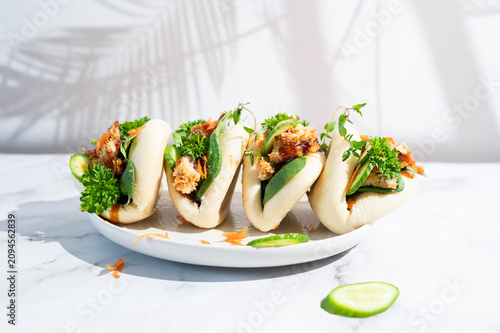Asian street food chicken teriyaki bao buns served on a plate.