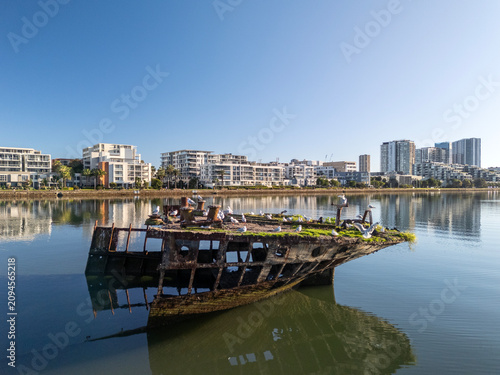 Shipwreck stern section with  rusty hull on sunny day from with architecture. Wreck in located in Homebush Bay, Parramatta river, Sydney Australia.
