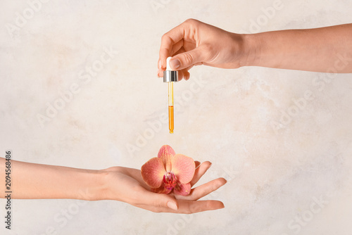 Hand holding a pink orchid ...
