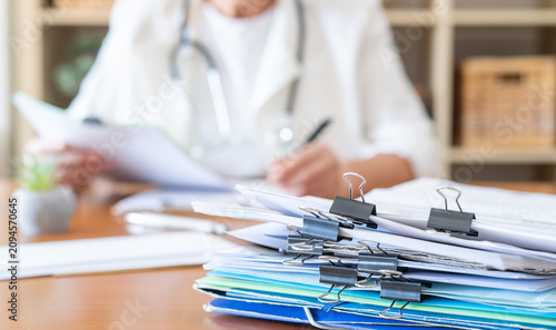 Foto Healthcare professional wearing a stethoscope is reviewing patient records and a