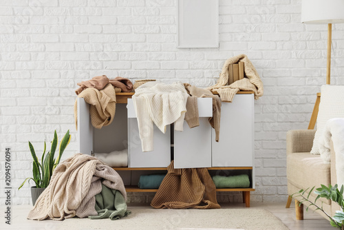 Foto Messy room with clothes piled on a dresser and floor, disorganization and househ