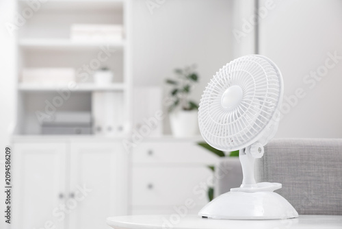 Bild auf Leinwand Electric fan on table in office, closeup