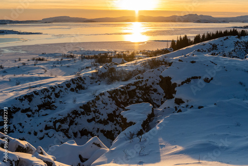 A scenic outdoor landscape shot from the Thingvellir National Park in Iceland on a beautiful sunny winter afternoon. This snowcovered landscape marks the continental divide between America and Europe.