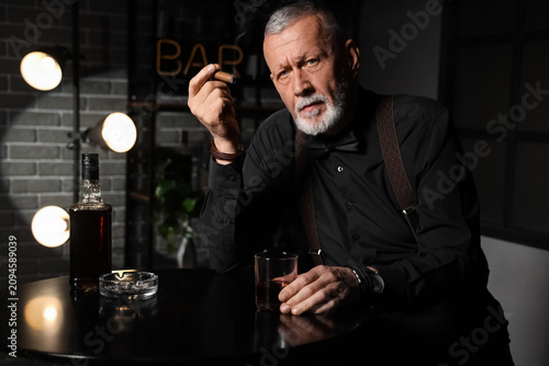 Stylish old man with glass ...