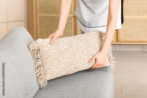 Female maid putting cushion...