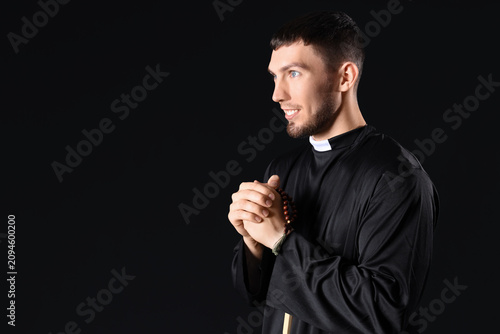 Young priest with praying b...