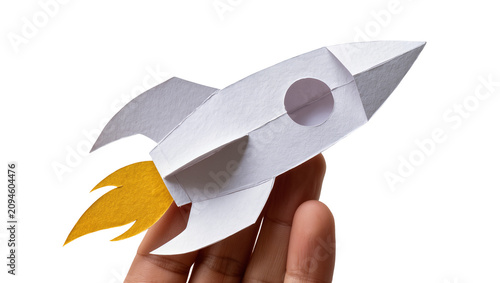 Photos Isolated paper rocket model held in human hand, symbolizing startup business lau