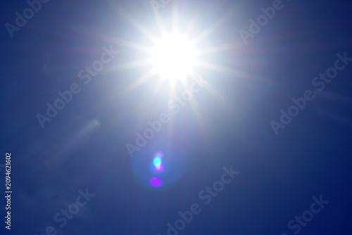 Obraz na płótnie Bright summer sunburst directly overhead in bright blue sky