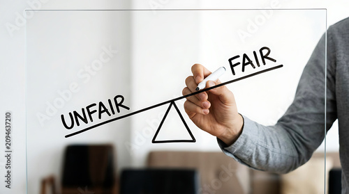 Hand adjusting fairness scale with marker, close-up