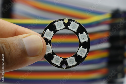 LED ring with individually addressable LEDs held in the hand. WS2812B circular board light
