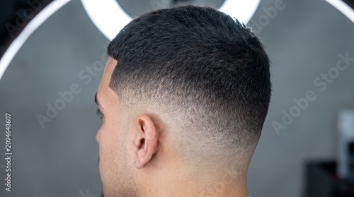 Modern skin fade haircut on male model, professional barber shop hairstyle with clean gradient, stylish short mens hair grooming and styling