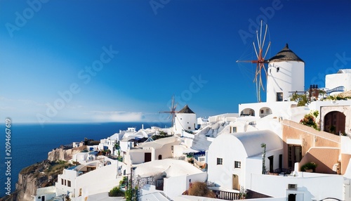 white houses and windmill in oia santorini greece
