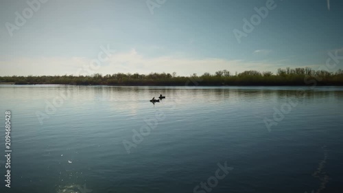 Tranquil Minimalist Waterscape: Solitary Row Boats with Fishermanes Gliding on Mirror-Like Lake at Golden Hour