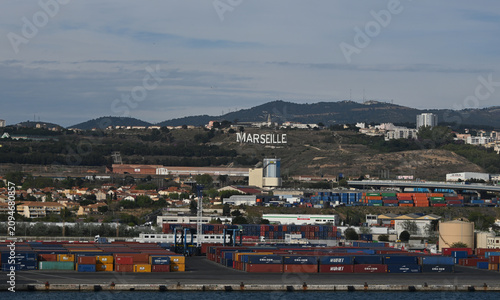 Panoramic view of the Port of Marseille in southern France featuring commercial harbor facilities, cargo terminals, waterfront development, and the Mediterranean coastline. Marseille is France's large