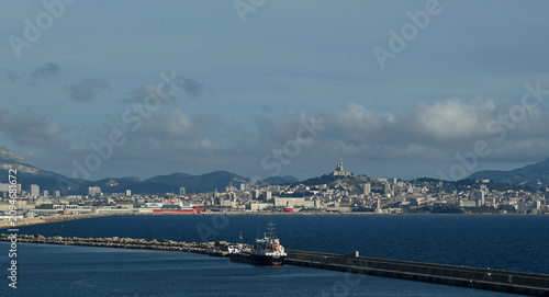 Panoramic view of the Port of Marseille in southern France featuring commercial harbor facilities, cargo terminals, waterfront development, and the Mediterranean coastline. Marseille is France's large