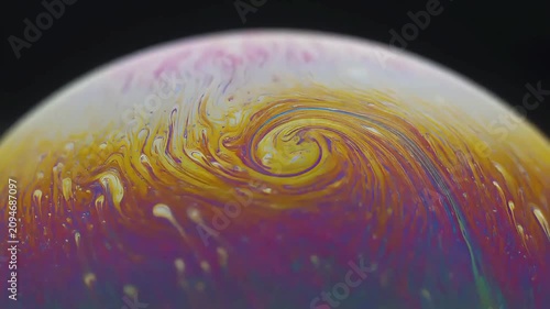 Macro shot of iridescent soap bubble surface with swirling colors