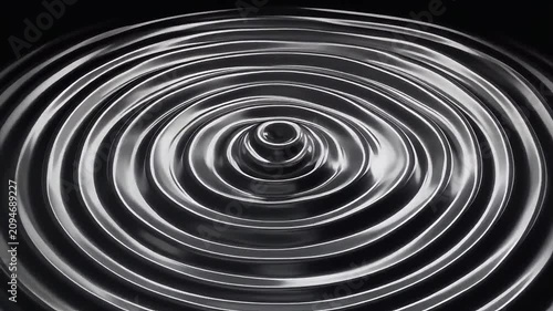 Concentric metallic ripples on a dark background