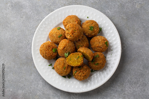Overhead view of crispy golden falafel balls served on a textured white plate