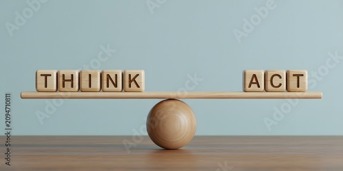 A wooden balance scale with think and act blocks on a table