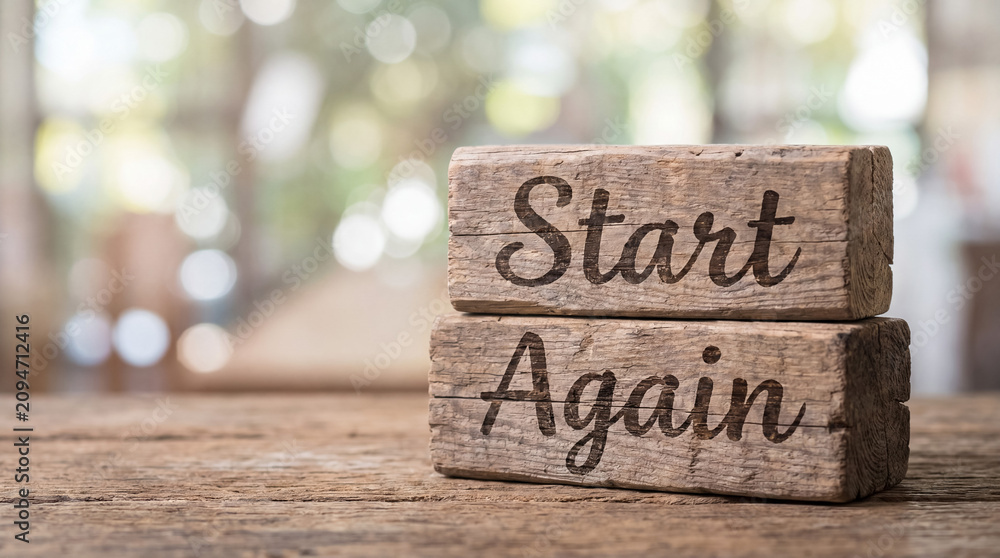 Fototapeta premium Wood blocks with phrase start again, symbolizing new beginnings, motivation, overcoming challenges, and a fresh start
