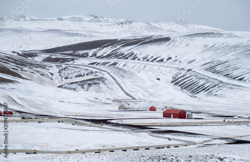 Krafla geothermal power plant releasing steam in a snow covered winter landscape, showcasing renewable energy production. Iceland icelandic landscape