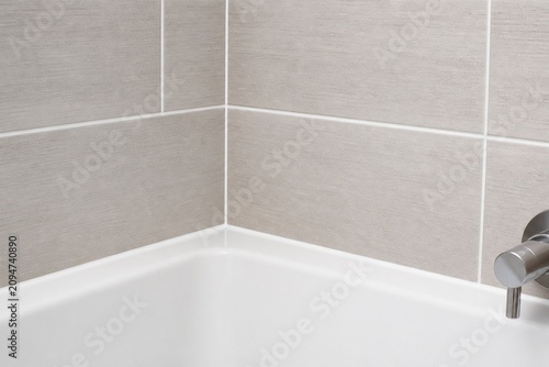 Bathroom tile grid with fresh white waterproof caulking lines.